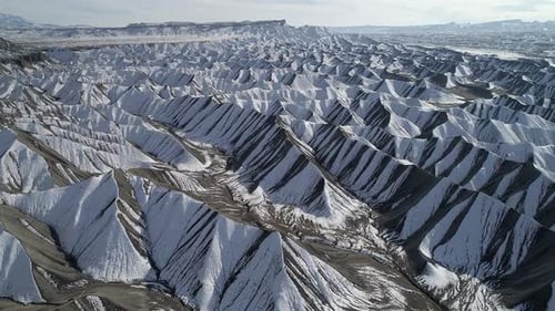 Aerial view flying over snow covered desert dunes in Utah