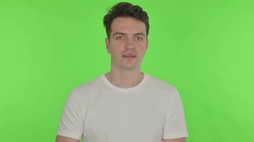 Thumbs Up By Young Man on Green Background