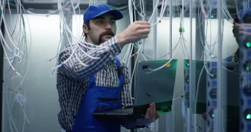 Technician Checking Cables in a Data Center