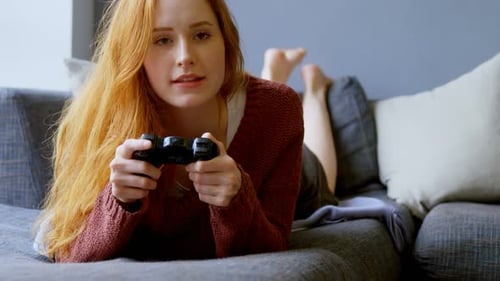 Focused Woman Plays Video Game on Couch