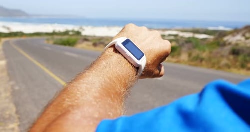 Adult Checks Smart Watch Near Beach Road