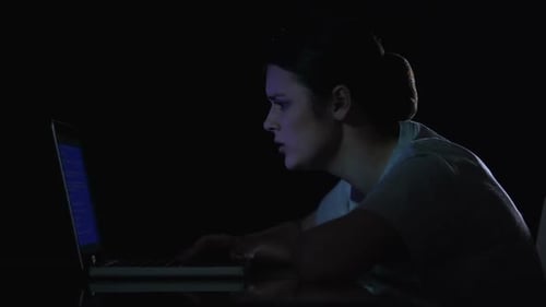 Woman working late into the night on laptop