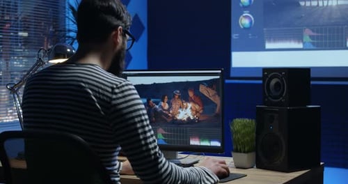 Joven sentado y editando Vídeo dentro de una habitación