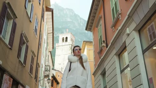 Woman Walks on Narrow Street Looking at Vintage Buildings