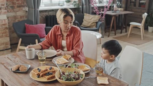 Mother and Child Eating Breakfast Indoors at Table