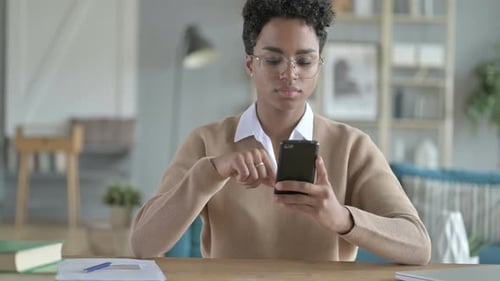 Young Adult Using Smartphone at Desk Indoors