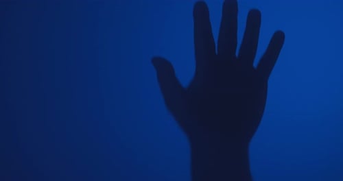 Hand Silhouette Slowly Moving Down on Blue