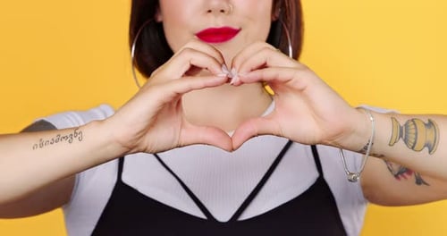 Woman Makes Heart Shape with Hands and Lipstick