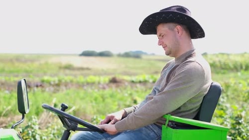 View of a Smiling Young Man Sitting in a Tractor Close Up