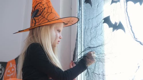 Girl in Witch Costume Decorating for Halloween