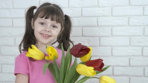 Cute Girl Smiling Holding a Tulip Bouquet