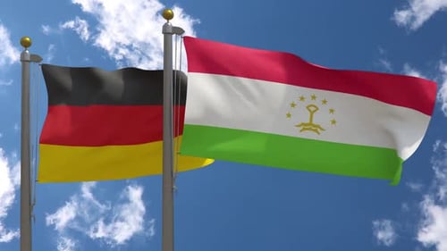 German and Tajik Flags Waving on Flagpoles Against Blue Sky