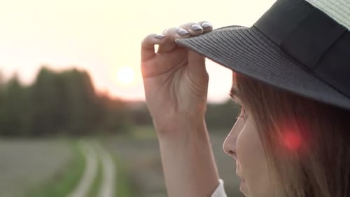 Woman in Hat Enjoying the Sunset in Field