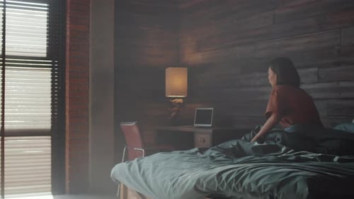 Young Woman Wakes Up and Uses Phone