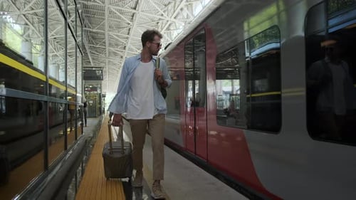 Man Pulling Suitcase at Modern Sunny Train Station