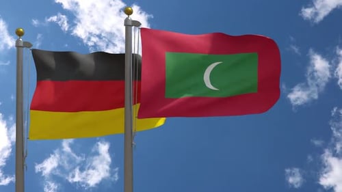 Flags of Germany and Maldives Waving Against Blue Sky