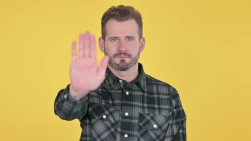 Portrait of Middle Aged Man Showing Stop Sign By Hand