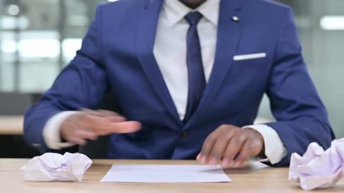 African Businessman Trying to Write Torn Paper