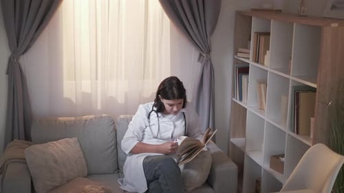 Female Doctor Reading a Book Indoors