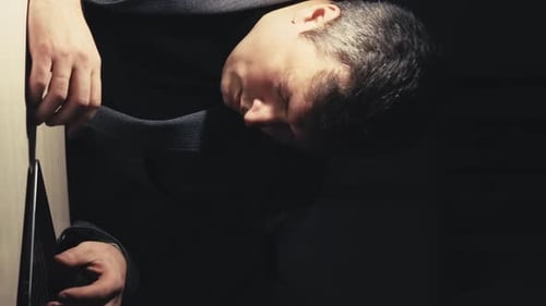Stressed Man in Suit Sitting in Dark Room