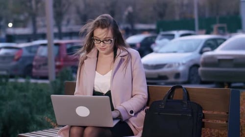 Young Woman Working on Laptop Outdoors in City