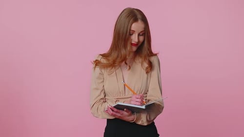 Professional Woman Writes in Notebook with Pencil