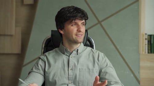 Portrait of Man Looking at Speaking at Camera Having Video Call From Office