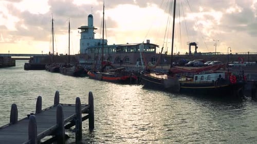 Boats Parked By a Shore in an Urban Area, Buildings, People and the Cloudy Dusk Sky