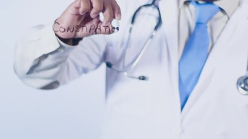Doctor Writes Word Constipation on Transparent Surface