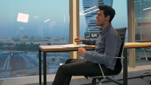 Happy Man Celebrates Success in High Rise Office