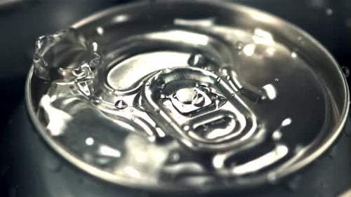 Super Slow Motion on a Tin with Beer Dripping Drops of Water with Spray