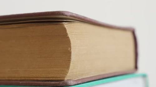 Old books darkened with shelf dust stacked 4K 2160p 30fps UltraHD tilting footage - Close-up of v