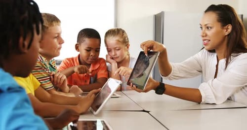 Teacher Teaching Kid on Digital Tablet in Library