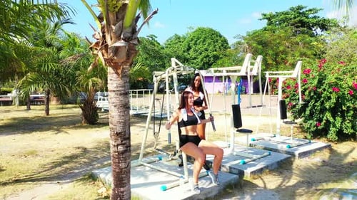 Sexy beauty models on photoshoot having fun at the beach on paradise white sand and blue background