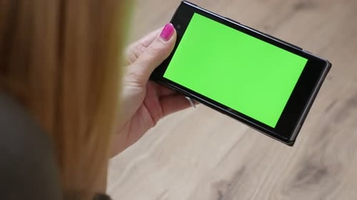 Woman holding green screen display mobile smart phone 4K 2160p 30fps UltraHD video - Female relaxing