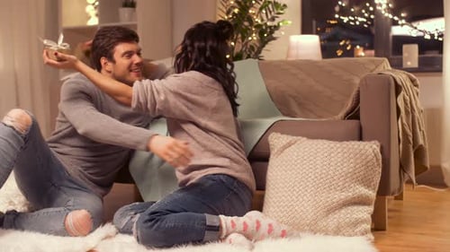 Woman Receives Gift from Man in Cozy Home