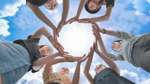 Friends Make a Circle From Their Palms Against the Background of a Fabulous Sky