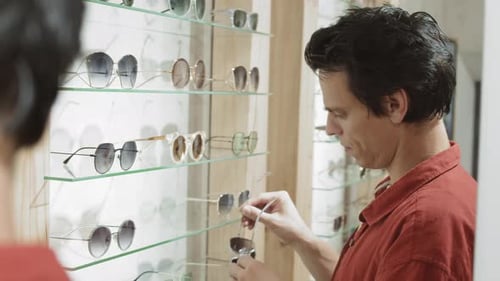 Handsome Young Man Choosing Sunglasses in Shop