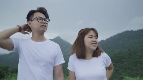 Hiker backpacker couple on hiking adventure feeling freedom walking in forest near lake in rainy day