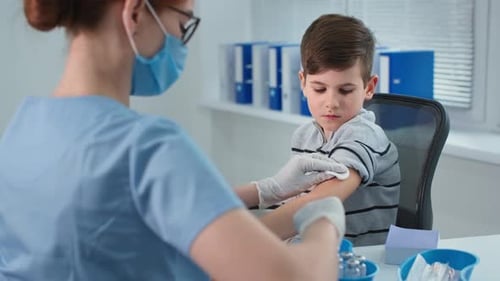 Boy Receives Vaccine from Medical Professional at Clinic