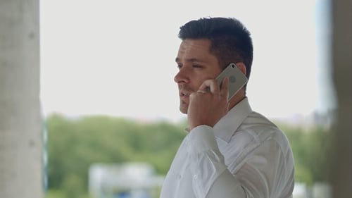 Man Talking on Smartphone in Modern Building