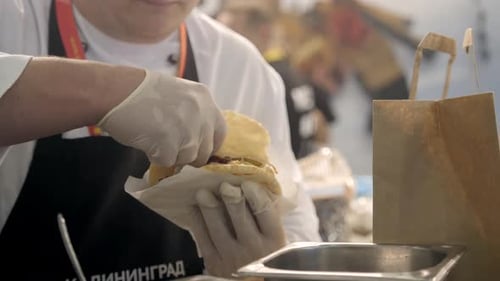 Chef Assembling Pita Sandwich in Restaurant Setting