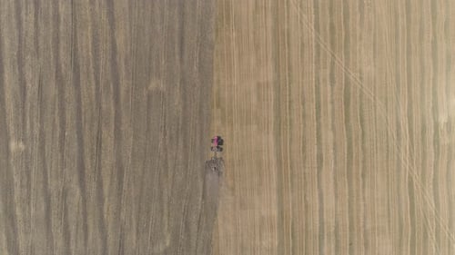 Aerial view of a tractor plowing on the fields
