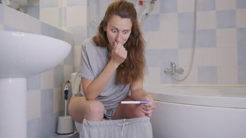 Woman Reacts to Pregnancy Test Results in Bathroom