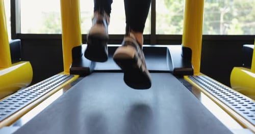 Beine laufen auf dem Laufband in einem Fitnessstudio