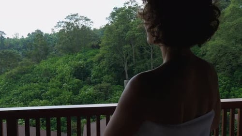 Back View of a Silhouette of a Woman Going on a Balcony After Morning Shower Holding White Mug of