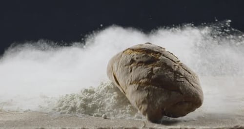 Bakery and Cooking Concept. Fresh Bread with a Splash Falls Into Flour
