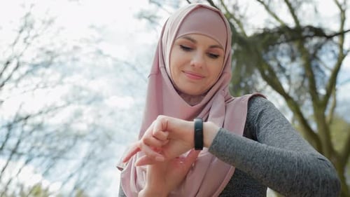 Woman Checking Fitness Tracker in the Park