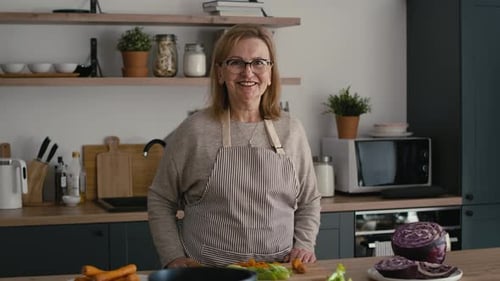 Woman Smiling in Kitchen with Fresh Vegetables