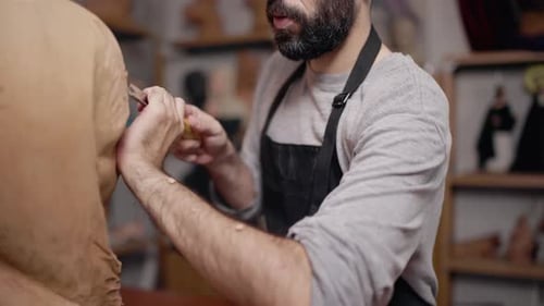 Sculptor Carefully Carving Details into Wooden Sculpture